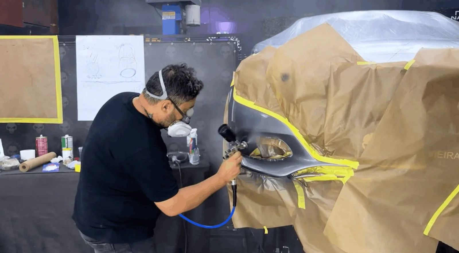 Junior Vieira pintando uma Mercedes fora da cabine de pintura